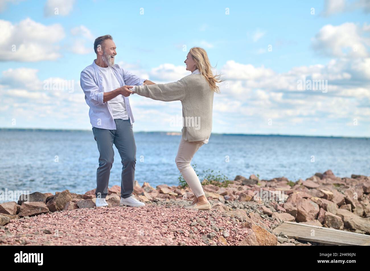 Energischer und glücklicher Mann und Frau in der Nähe des Meeres Stockfoto