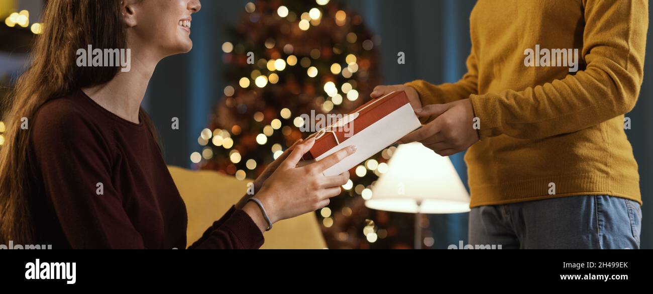 Glückliches Mädchen erhält ein schönes Weihnachtsgeschenk von ihrer Mutter Stockfoto