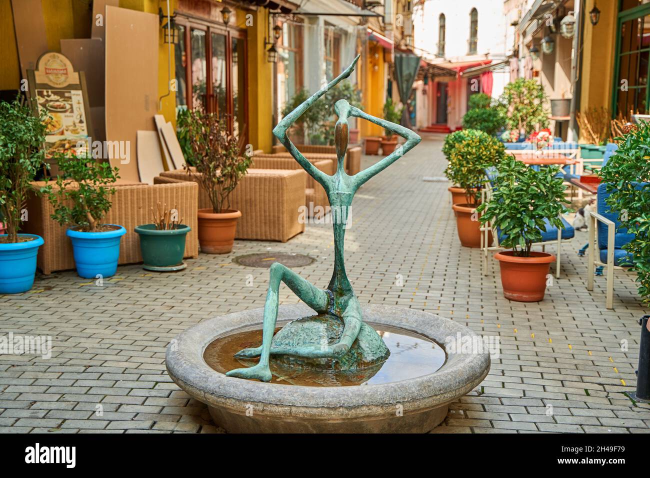 Ein Brunnen mit einer ungewöhnlichen dünnen Skulptur in der Mitte der Straße der Altstadt. Tiflis, Georgien - 03.16.2021 Stockfoto