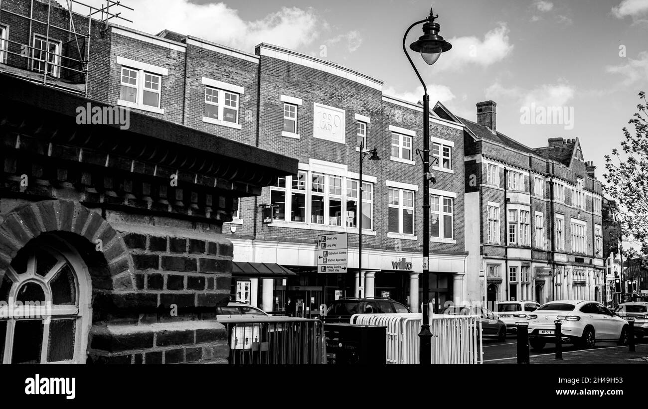 Epsom Surrey London, Octoober 31 2021, Black And White Image Town Center High Street Mit Der Handelskette Wlko Discount Supermarket Und Vorbeifahrenden Verkehr Stockfoto