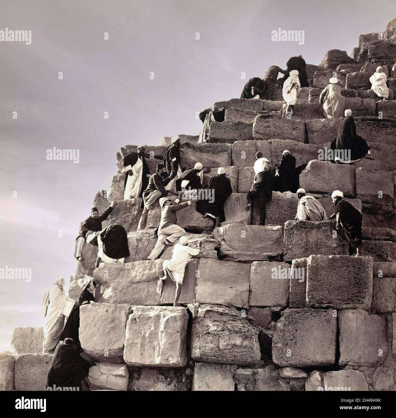 Mitte des 19. Jahrhunderts besteigen Touristen die große Pyramide von Gizeh mit Hilfe von lokalen Führern. Die große Pyramide von Gizeh, manchmal auch die Pyramide von Khufu oder die Pyramide von Cheops genannt, die größte der Gizeh Pyramidenkomplex in Gizeh, außerhalb von Kairo, Ägypten. Der Pyramidenkomplex von Gizeh ist heute Teil des UNESCO-Weltkulturerbes. Es ist derzeit verboten, die Pyramide zu besteigen. Das Bild wurde vom französischen Fotografen Henri Bechard aufgenommen. Stockfoto Mitte des 19. Jahrhunderts besteigen Touristen die große Pyramide von Gizeh mit Hilfe von lokalen Führern. Die große Pyramide von Gizeh, manchmal auch die Pyramide von Khufu oder die Pyramide von Cheops genannt, die größte der Gizeh Pyramidenkomplex in Gizeh, außerhalb von Kairo, Ägypten. Der Pyramidenkomplex von Gizeh ist heute Teil des UNESCO-Weltkulturerbes. Es ist derzeit verboten, die Pyramide zu besteigen. Das Bild wurde vom französischen Fotografen Henri Bechard aufgenommen. Stockfoto