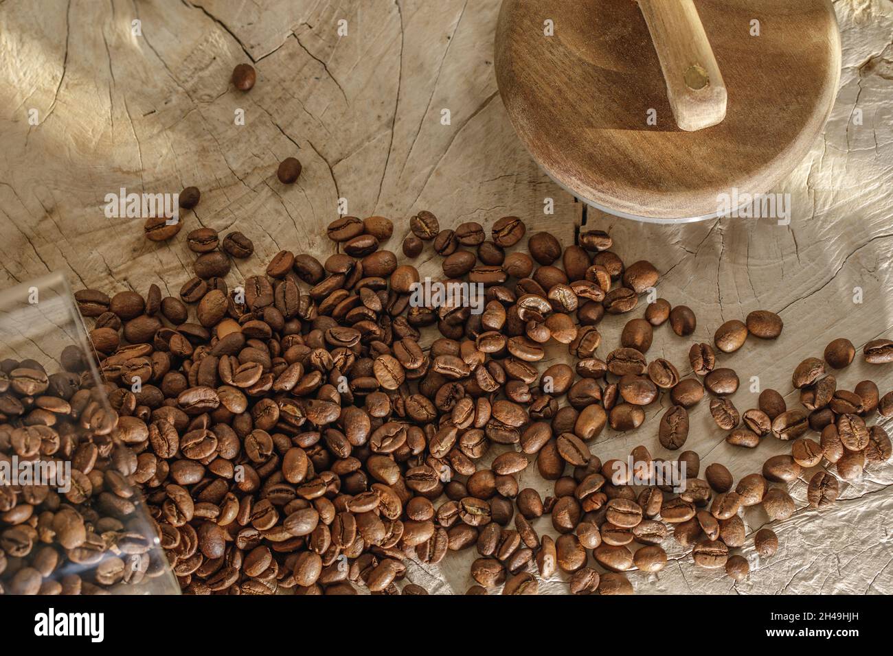 Kaffeebohnen im Glas mit Holzdeckel auf massivem Holz cremiger Stumpf Stockfoto