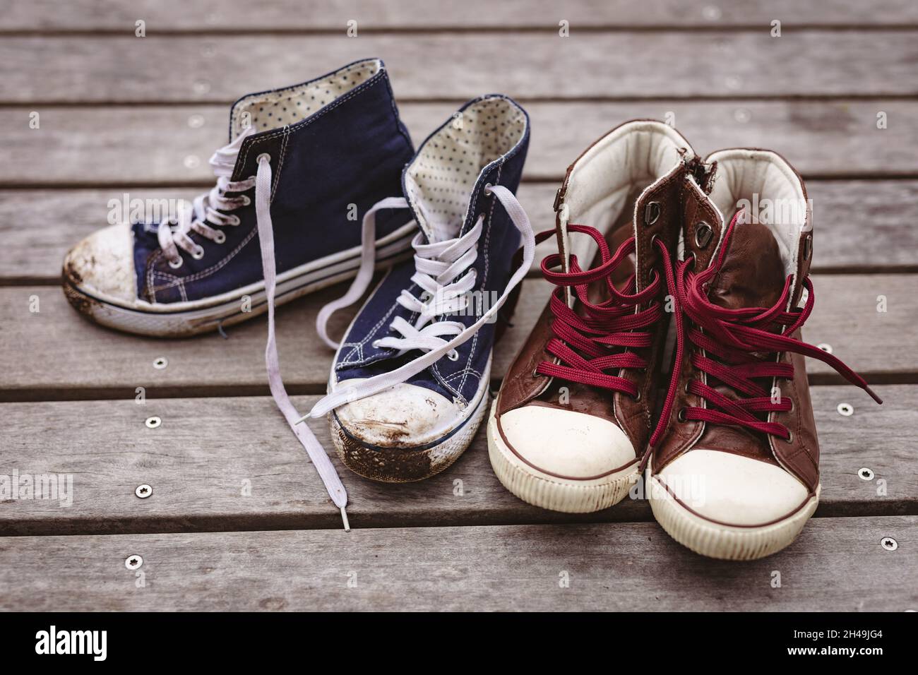 Nahaufnahme von schmutzigem blauem Canvas mit einem roten Paar neuer Schuhe auf dem Dielenboden Stockfoto