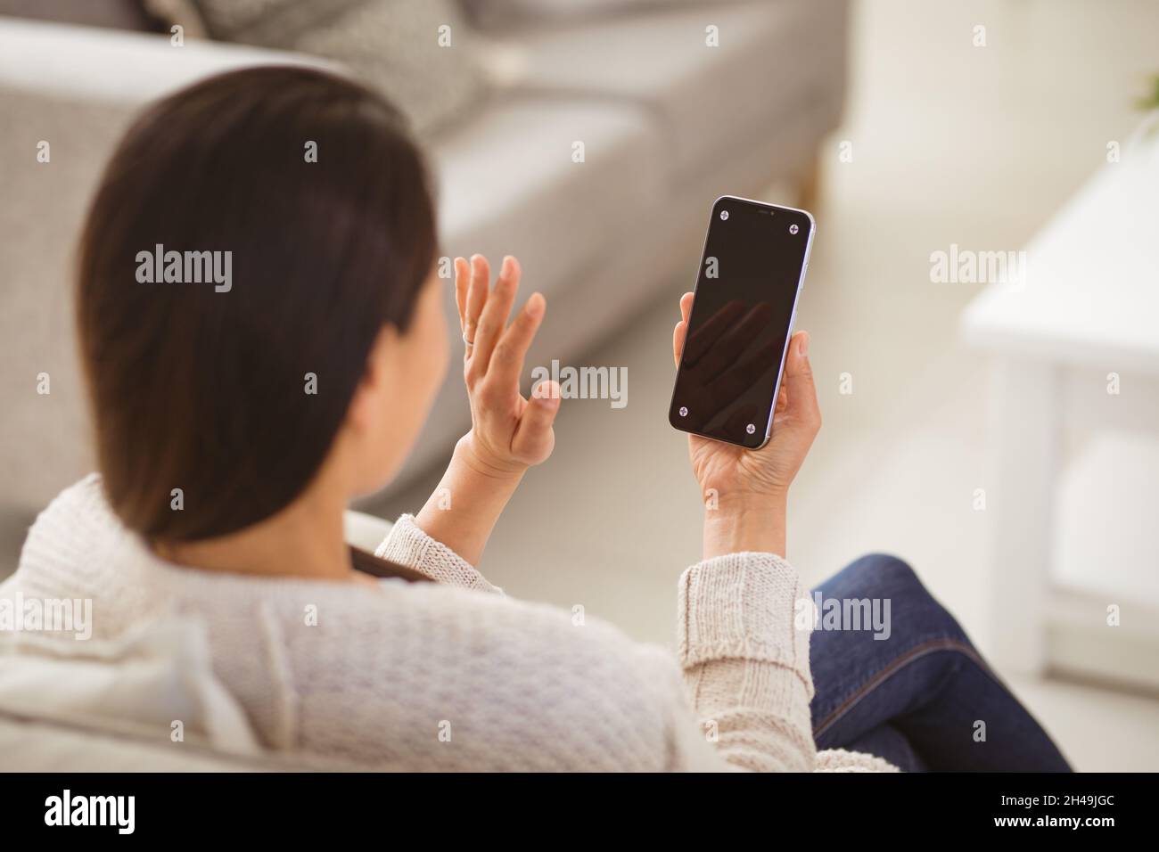 Rückansicht der asiatischen Frau mit Videoanruf auf dem Smartphone mit Kopierplatz auf dem Bildschirm Stockfoto