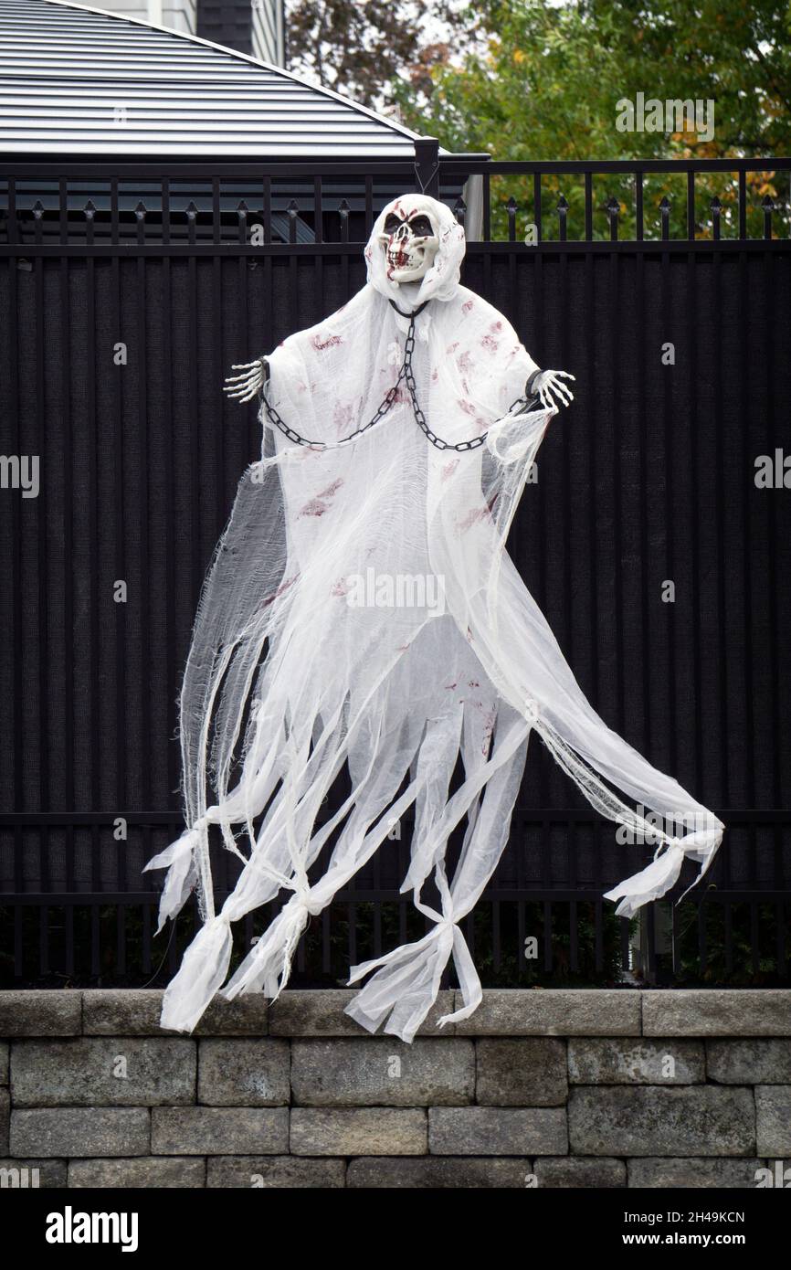 HALLOWEEN-DEKORATIONEN. Ein lebensgroßer Geist, der sich im Wind als Teil aufwändiger Dekorationen außerhalb eines Hauses in Flushing, Queens, New York City, bewegt. Stockfoto