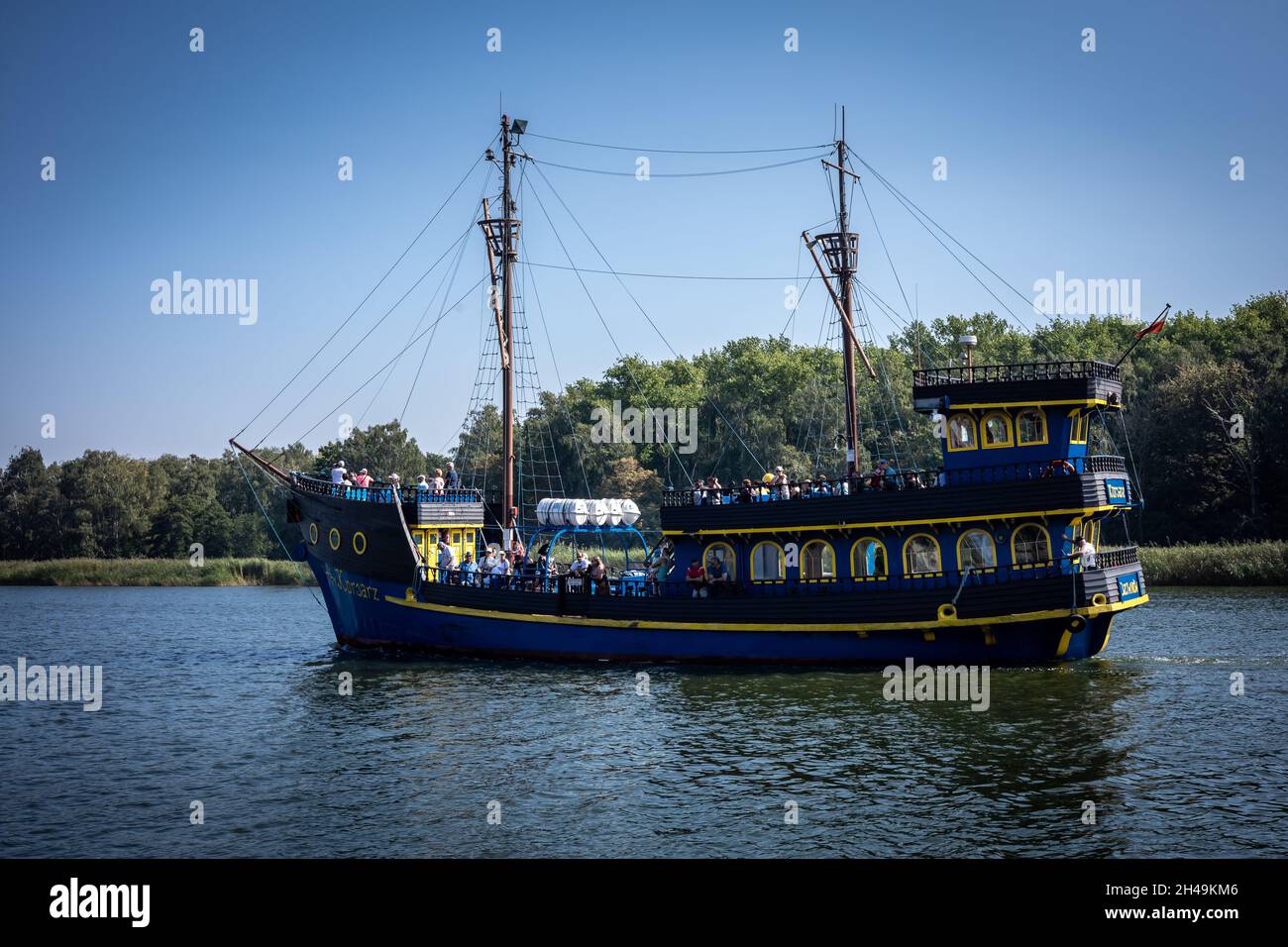 Dziwnow, Polen - 10. September 2021: Ein blau-gelbes Touristenboot, das auf dem Dziwna-Kanal segelt. Stockfoto