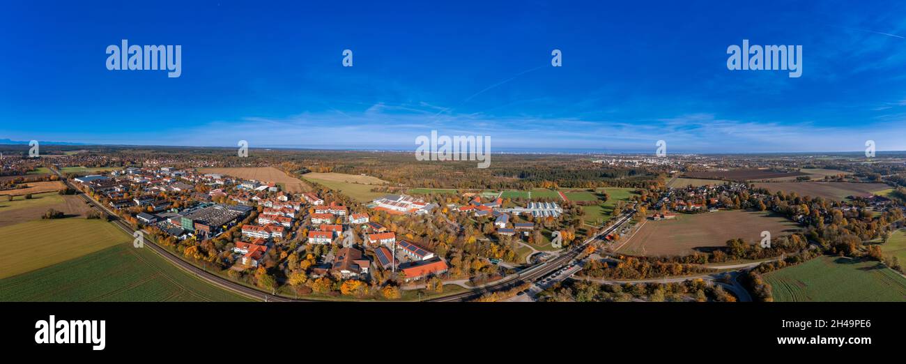 Weitblick über die bayerische Stadt Oberhaching in den Farben des indischen Sommers als Panorama-Luftaufnahme. Stockfoto