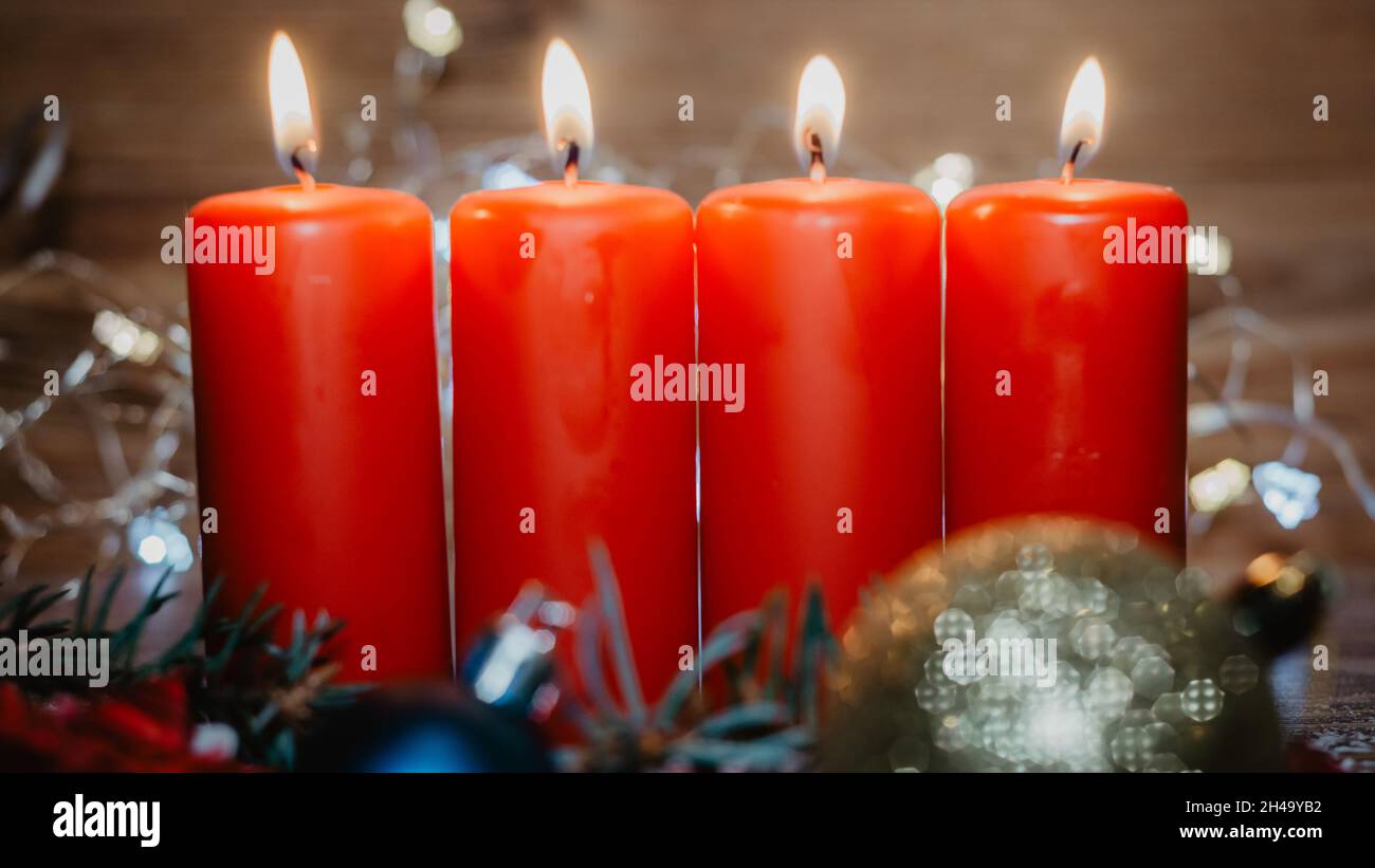 Vier rote Adventskerzen mit vier Kerzen angezündet und weihnachtsdekoration im Schnee als Vorlage Stockfoto