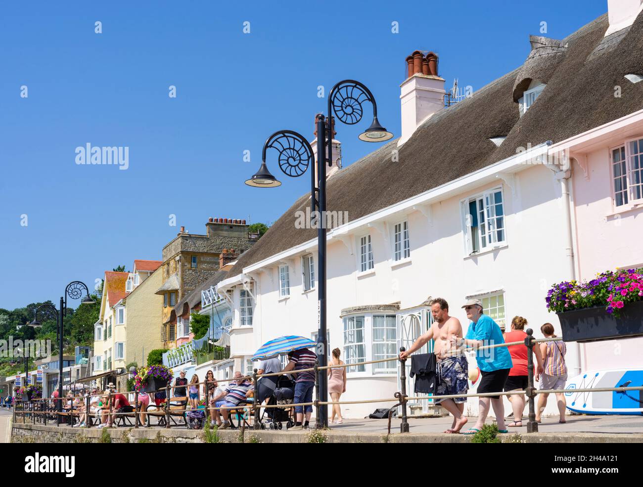 Menschen, die an der Strandpromenade der Marine Parade mit Blick auf den Sandstrand bei Lyme Regis Dorset England GB Europa spazieren gehen Stockfoto