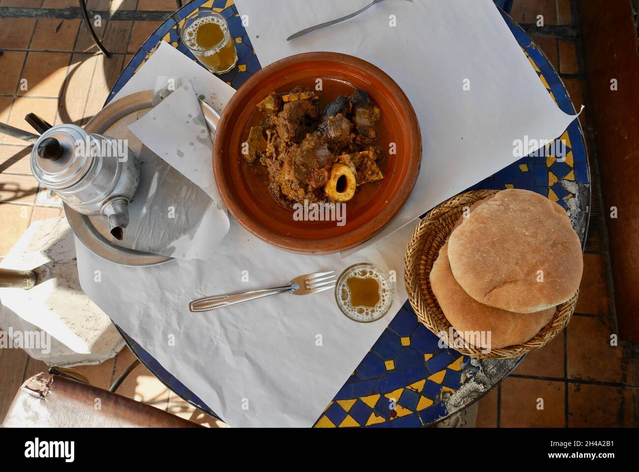 Beliebte lokale Gerichte Tangia, Tanjia, gebratenes Lamm in Tontöpfen im Hammam Ofen, serviert mit Brot und Minztee. Marrakesch, Marokko. Stockfoto