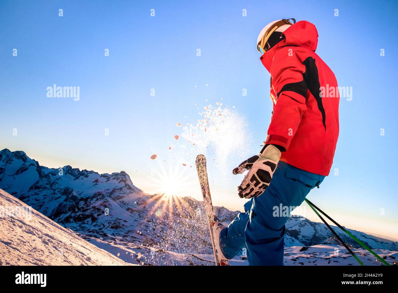 Profi-Skifahrer bei Sonnenuntergang im Erholungsmoment im skigebiet der französischen alpen - Wintersport-Konzept mit Abenteuermann auf der Bergspitze, der bereit ist, hinunter zu fahren Stockfoto