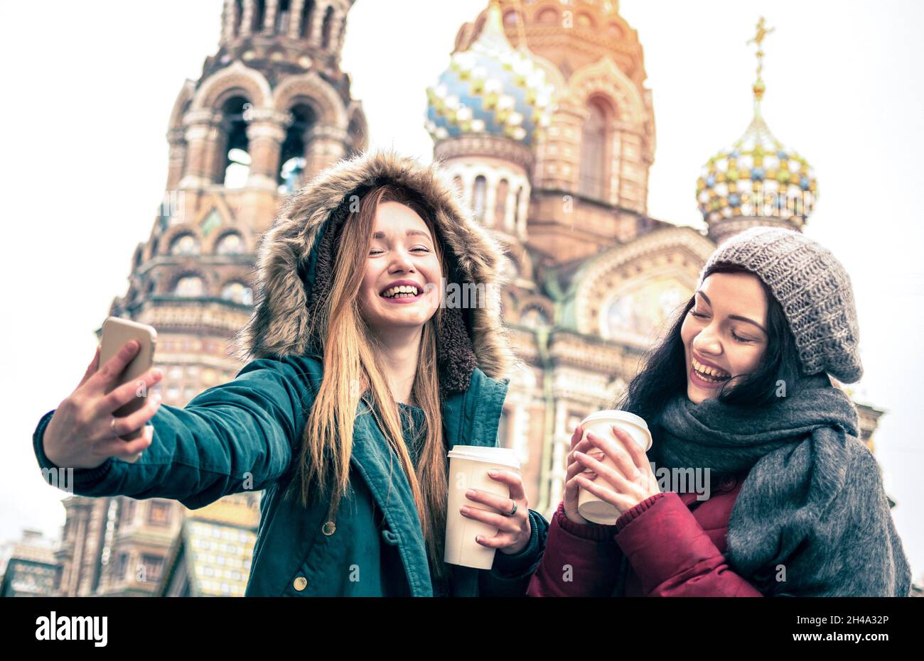 Glückliche Freundinnen, die ein Winter-Selfie in der Kirche „Retter auf vergossenen Blut“ in Sankt Petersburg machen – Freundschaftskonzept mit Mädchen, die Spaß miteinander haben Stockfoto