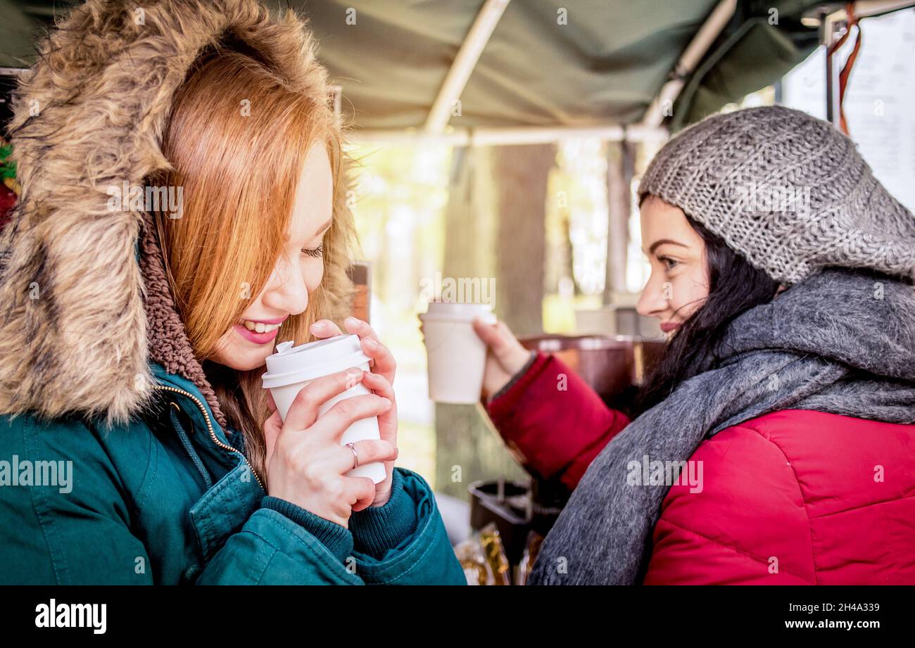 Glückliche Freundinnen beste Freunde teilen Zeit zusammen mit Kaffee zum Mitnehmen Tasse im Herbst - Frauen Freundschaft Konzept mit fröhlichen Mädchen Spaß haben Stockfoto