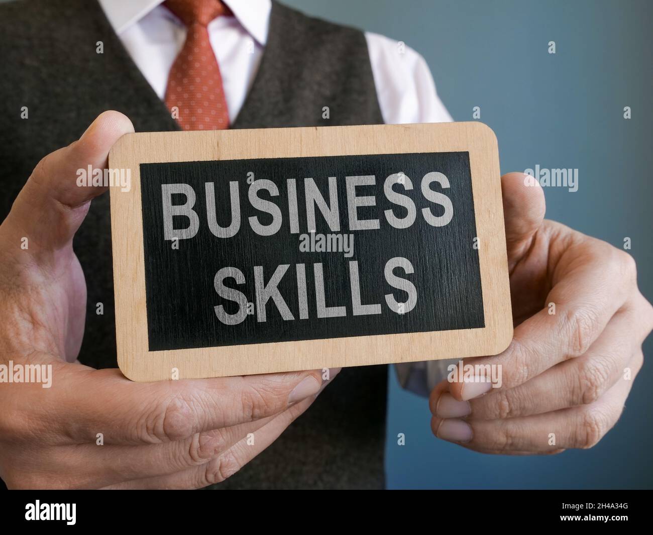 Geschäftsmann zeigt die Aufschrift Business Skills auf dem Teller. Stockfoto