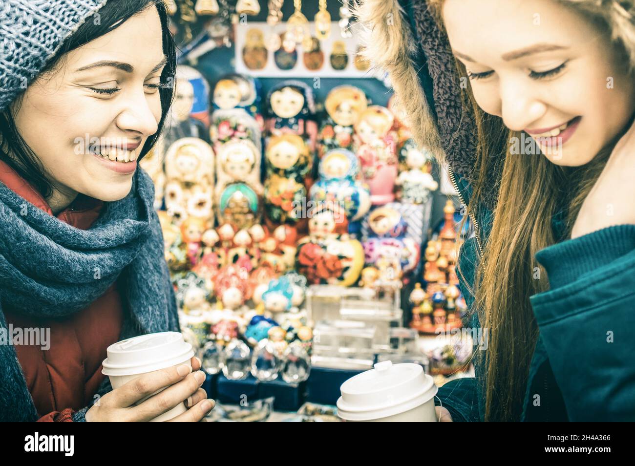 Glückliche Freundinnen beste Freunde teilen Zeit zusammen mit Kaffee zum Mitnehmen Tasse auf dem russischen Wintermarkt - Frauen Freundschaft Konzept mit fröhlichen Mädchen Stockfoto