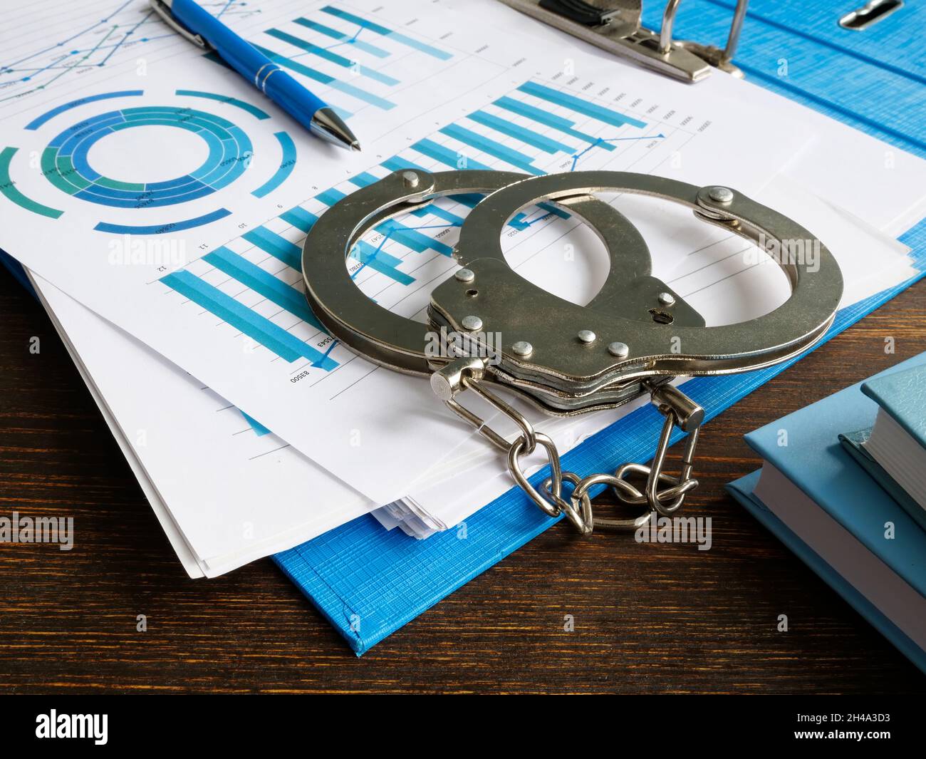 Konzept der Finanzkriminalität. Handschellen und Ordner mit Audit-Bericht. Stockfoto