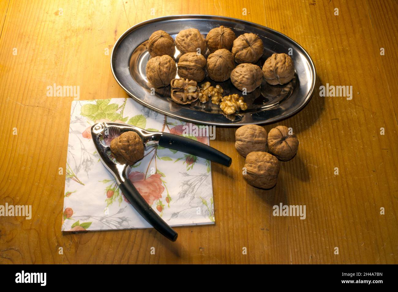 Walnüsse auf Tablett mit Nussknacker Stockfoto