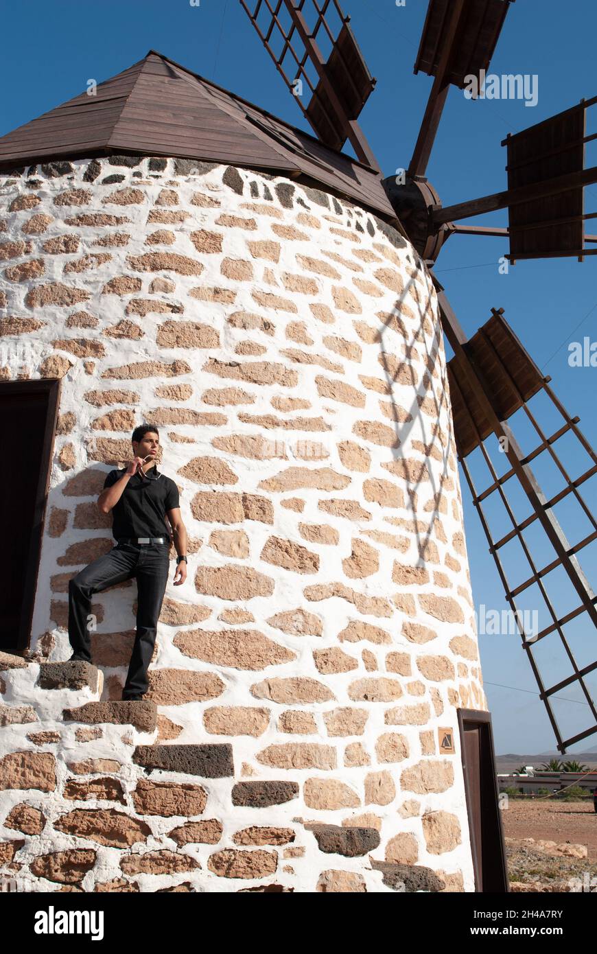 Mann, der sich an die Wand einer Windmühle lehnt Stockfoto