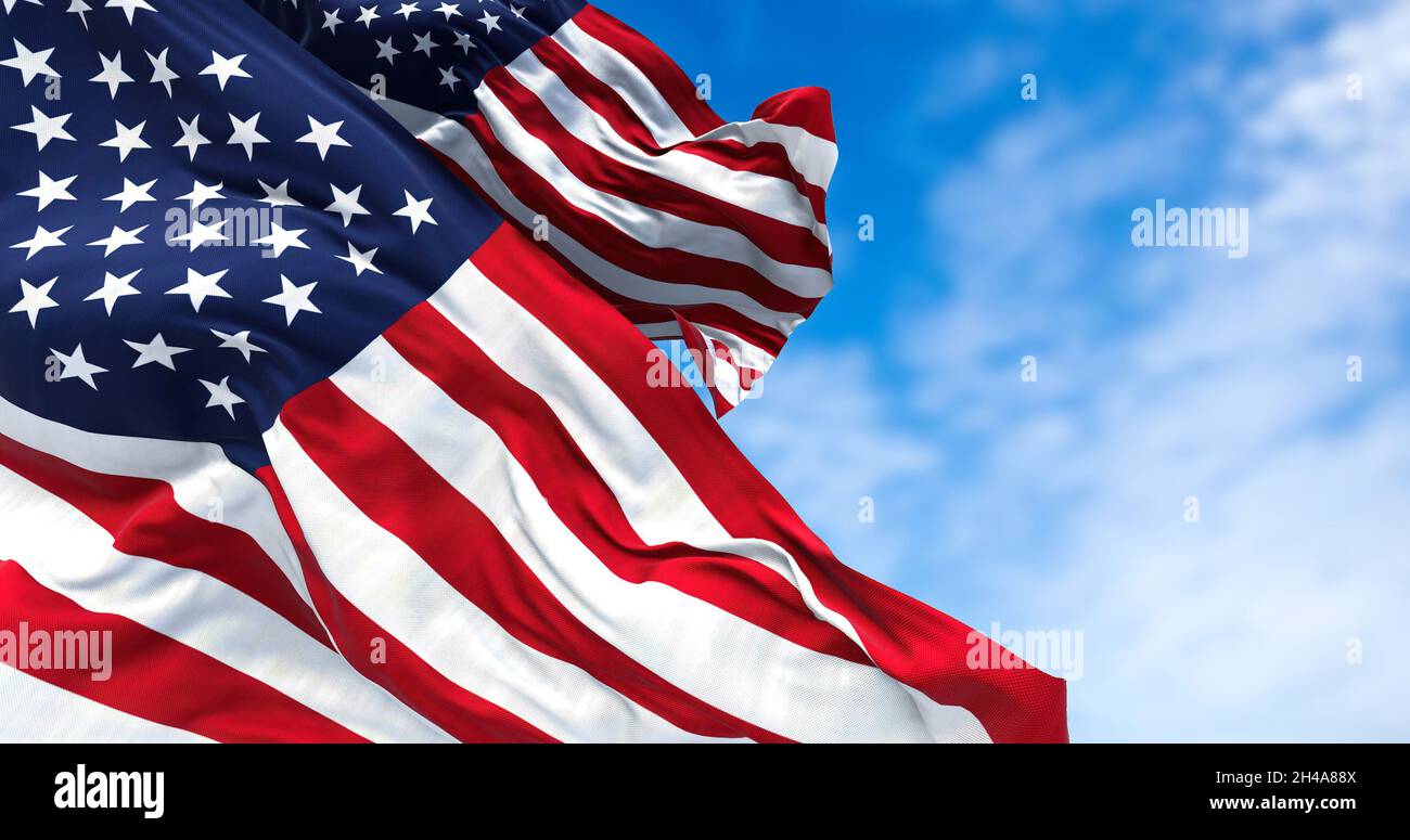 Zwei Flaggen der Vereinigten Staaten von Amerika winken im Wind. Klarer Himmel im Hintergrund. Selektiver Fokus. Demokratie, Unabhängigkeit und Wahltag. Stockfoto