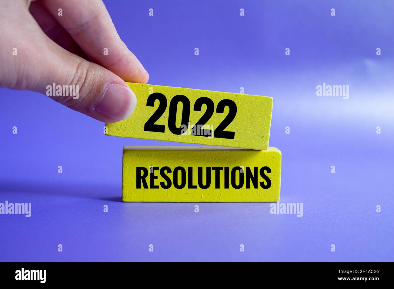 Neues Jahr 2022 Konzept, eine Hand fügt eine neue auf den Stapel von Holzblöcken, die sagt 2022 Auflösungen. Stockfoto