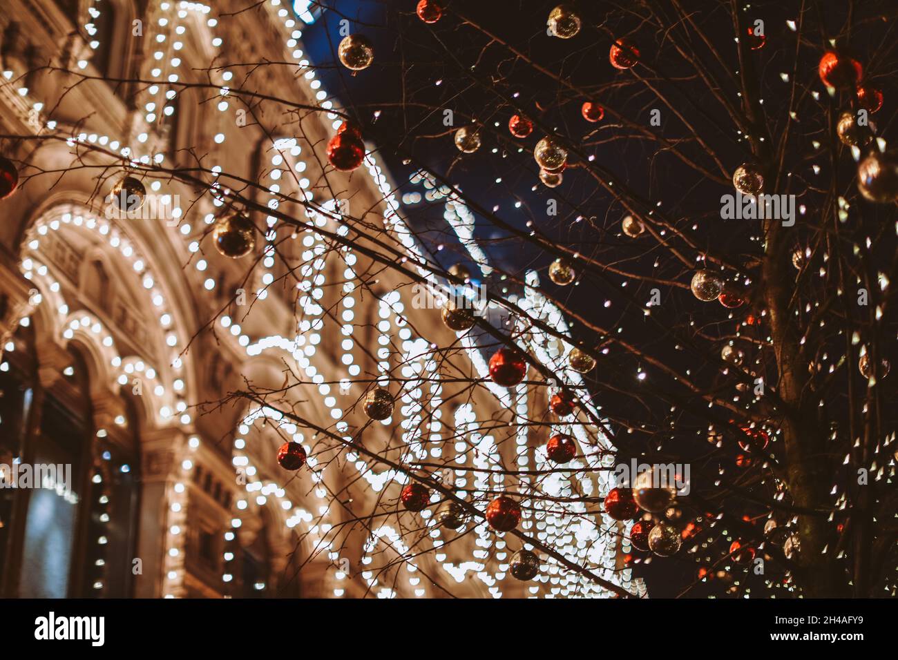 Weihnachten und Neujahr in Moskau. Nachtlicht scheint und leuchtet in der Nähe VON KAUGUMMI. Stadtstraße für Weihnachten dekoriert. Winterliches Stadtbild Stockfoto
