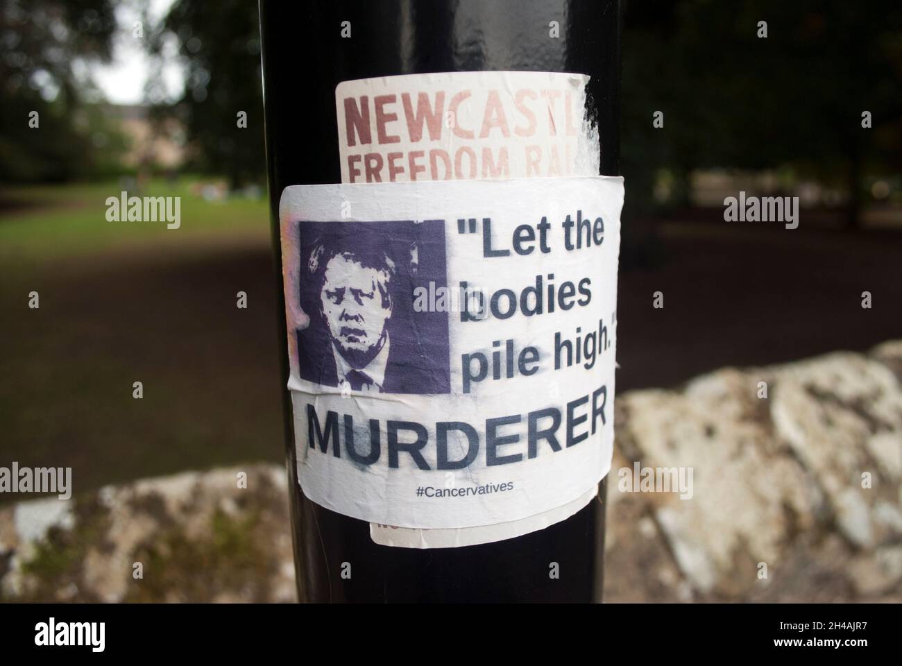 Boris Johnson „Lass die Körper HOCHMÖRDERISCH anhäufen“-Aufkleber auf dem Laternenpfahl in Hexham Park, Hexham, Northumberland, England, Großbritannien Stockfoto