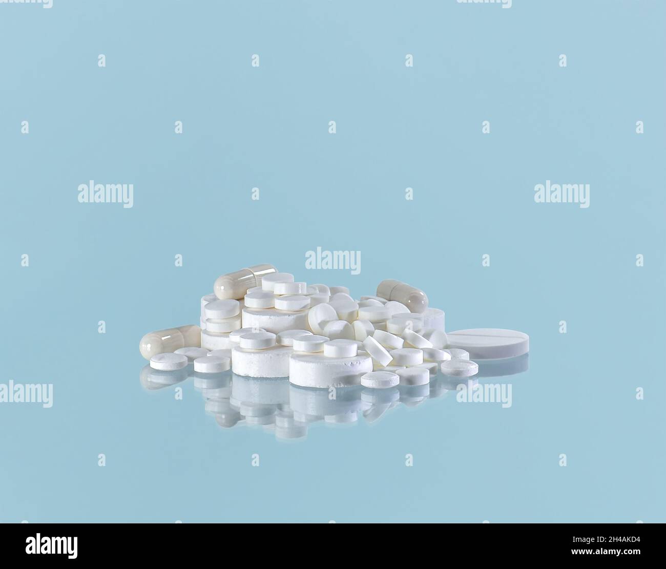 Ein Haufen Berge weiße Pillen auf einem blauen Hintergrund. Stockfoto