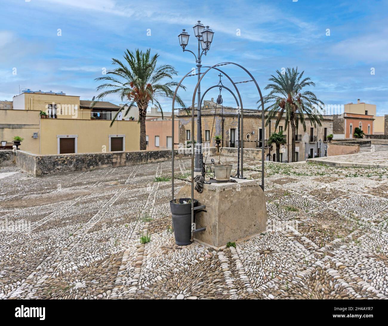 Der alte Brunnen außerhalb der römisch-katholischen Kirche des Heiligtums von Maria Santissima di Custonaci, Sizilien, Italien. Die Kirche stammt aus dem 16. Jahrhundert. Stockfoto