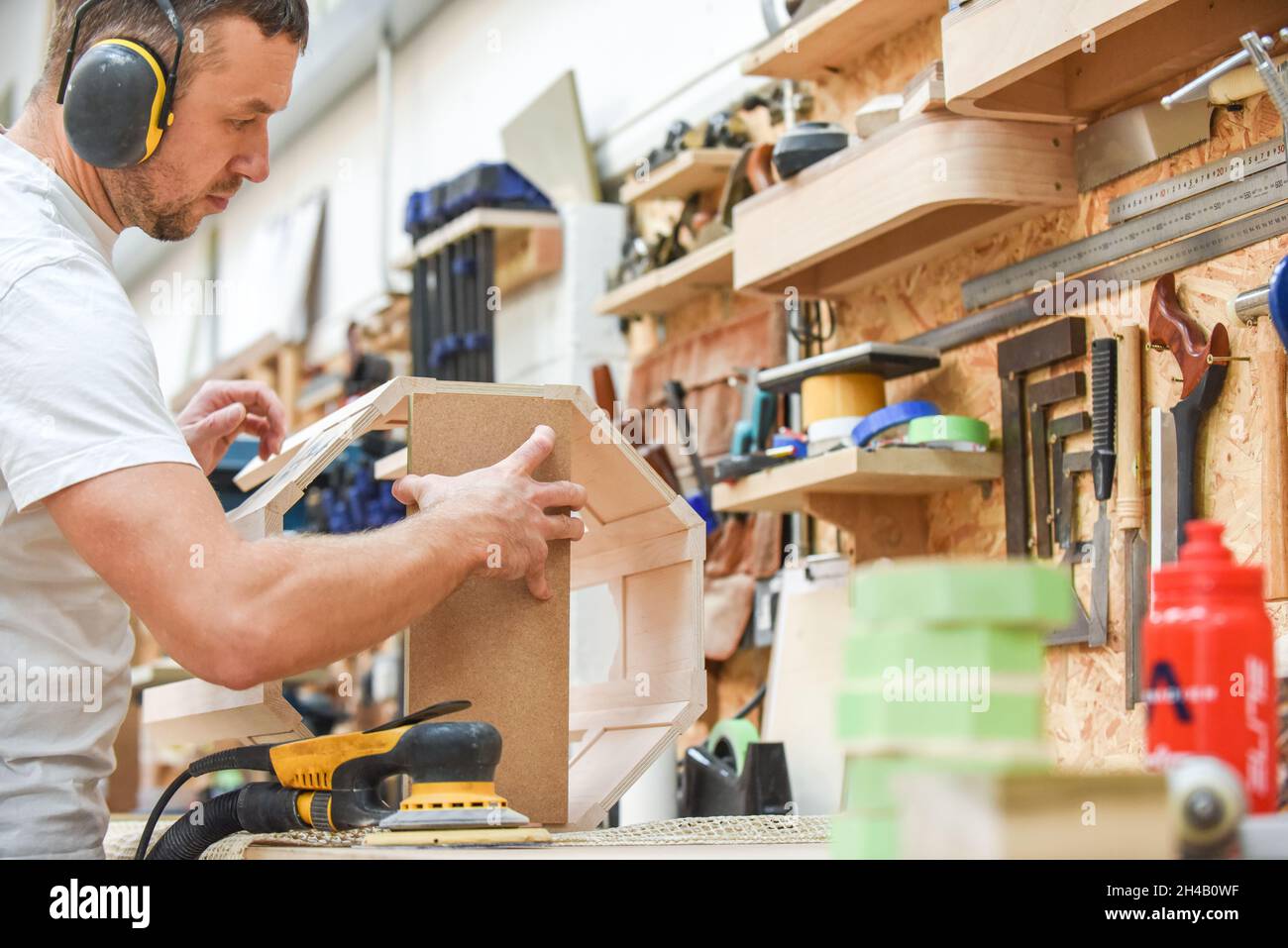 Zimmermann, der in einer Werkstatt Möbel macht der Mann stellt Holzprodukte von Hand her Stockfoto