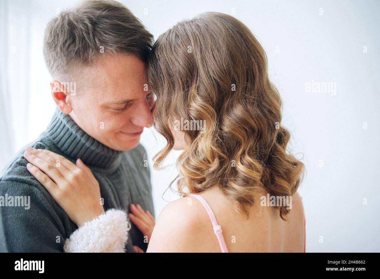 Junge liebevolle Paar in zärtlicher Umarmung voneinander. Berührender Moment Stockfoto