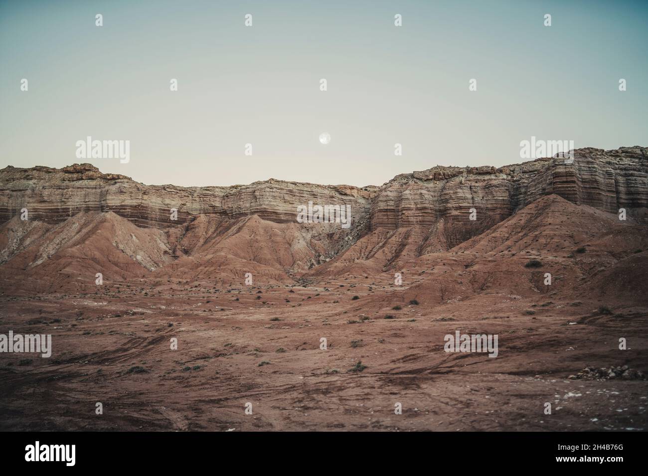 Der Mond steigt über einer orangefarbenen mesa in der Wüste von Utah auf Stockfoto