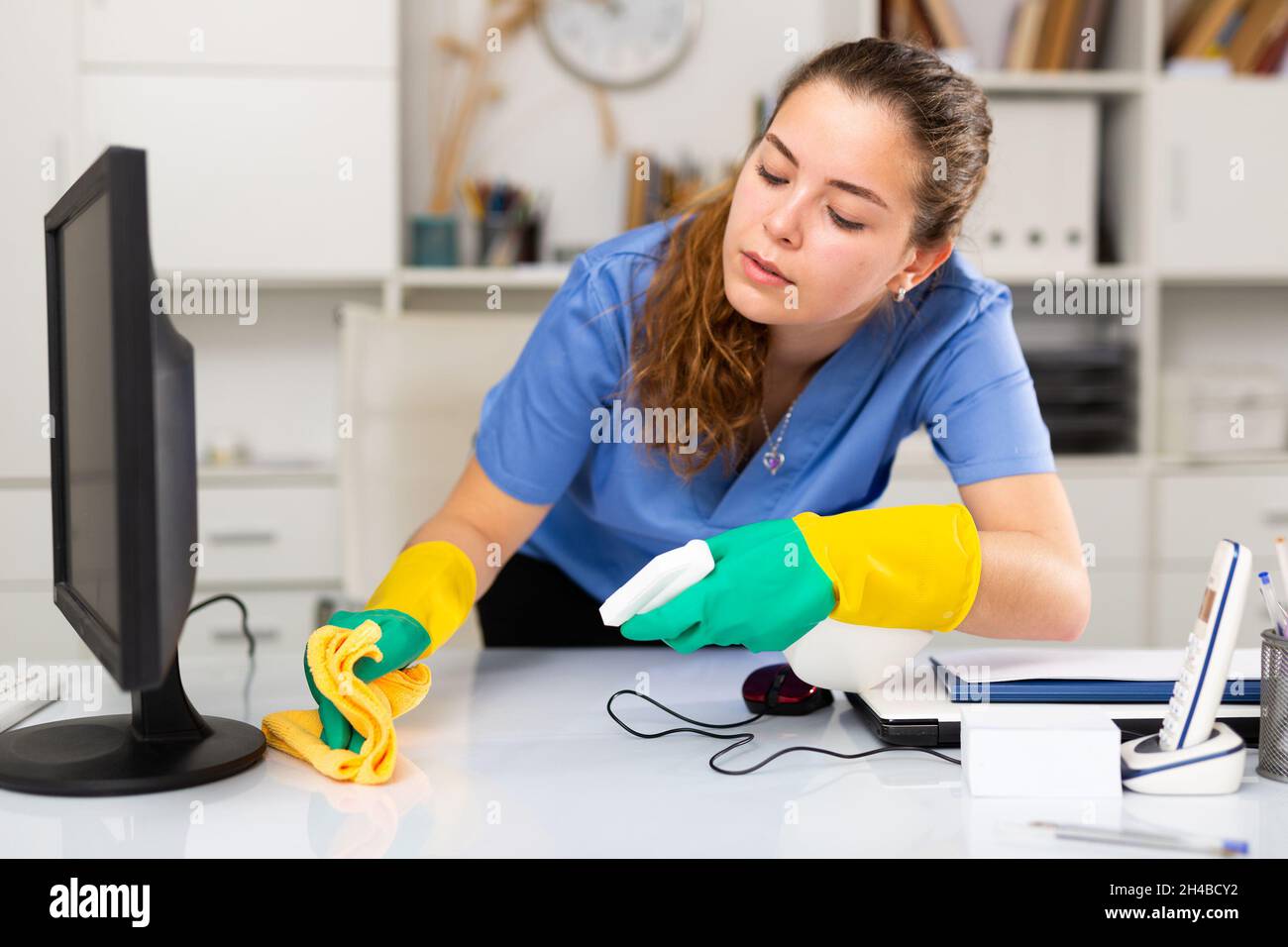 Junge freundliche Putzfrau in Arbeitsuniform Stockfoto