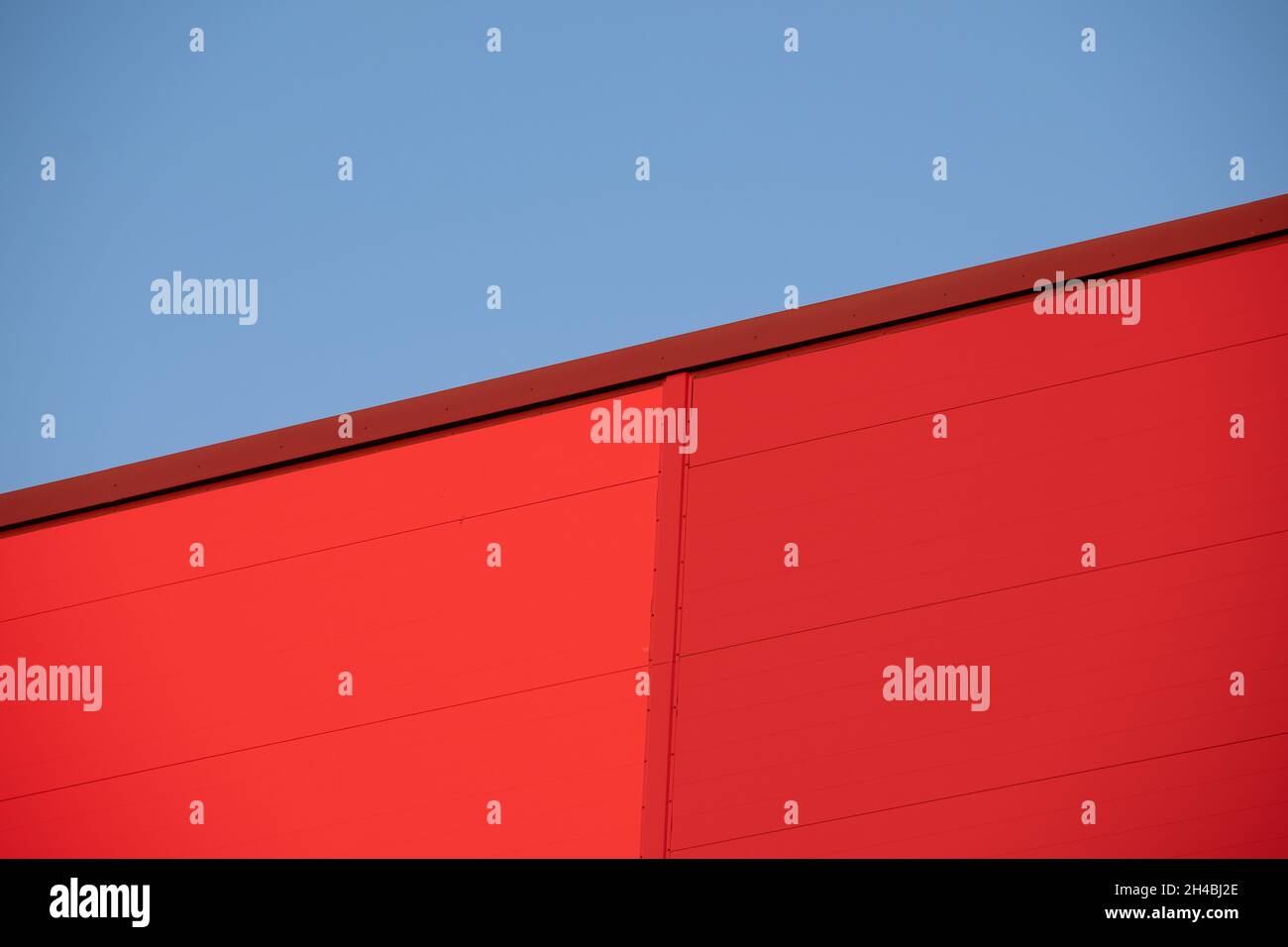 Helsinki / Finnland - 1. NOVEMBER 2021: Nahaufnahme einer roten Metallwand vor dem strahlend blauen Himmel während des Sonnenuntergangs. Stockfoto