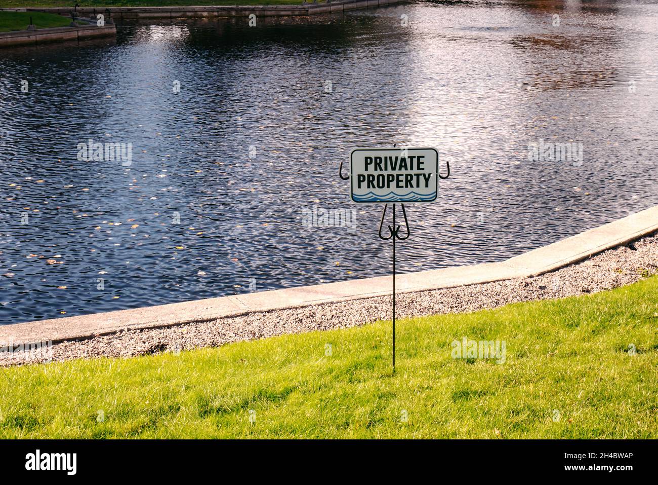 Privates Grundstück Schild auf Gras mit Wasser dahinter Stockfoto