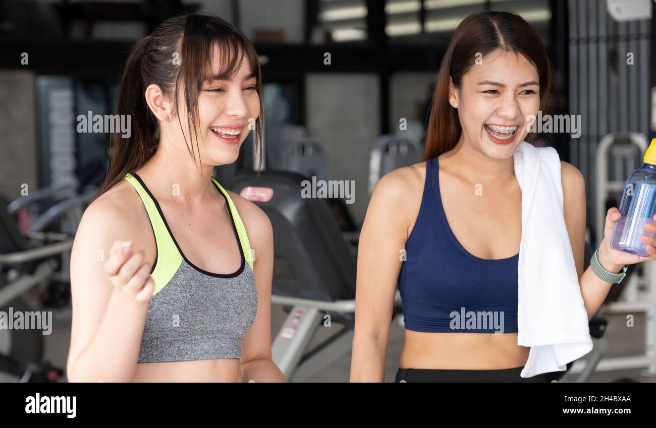 Glückliches zwei fleckiges Mädchen, das nach dem Training im Fitnessstudio miteinander redet. Stockfoto