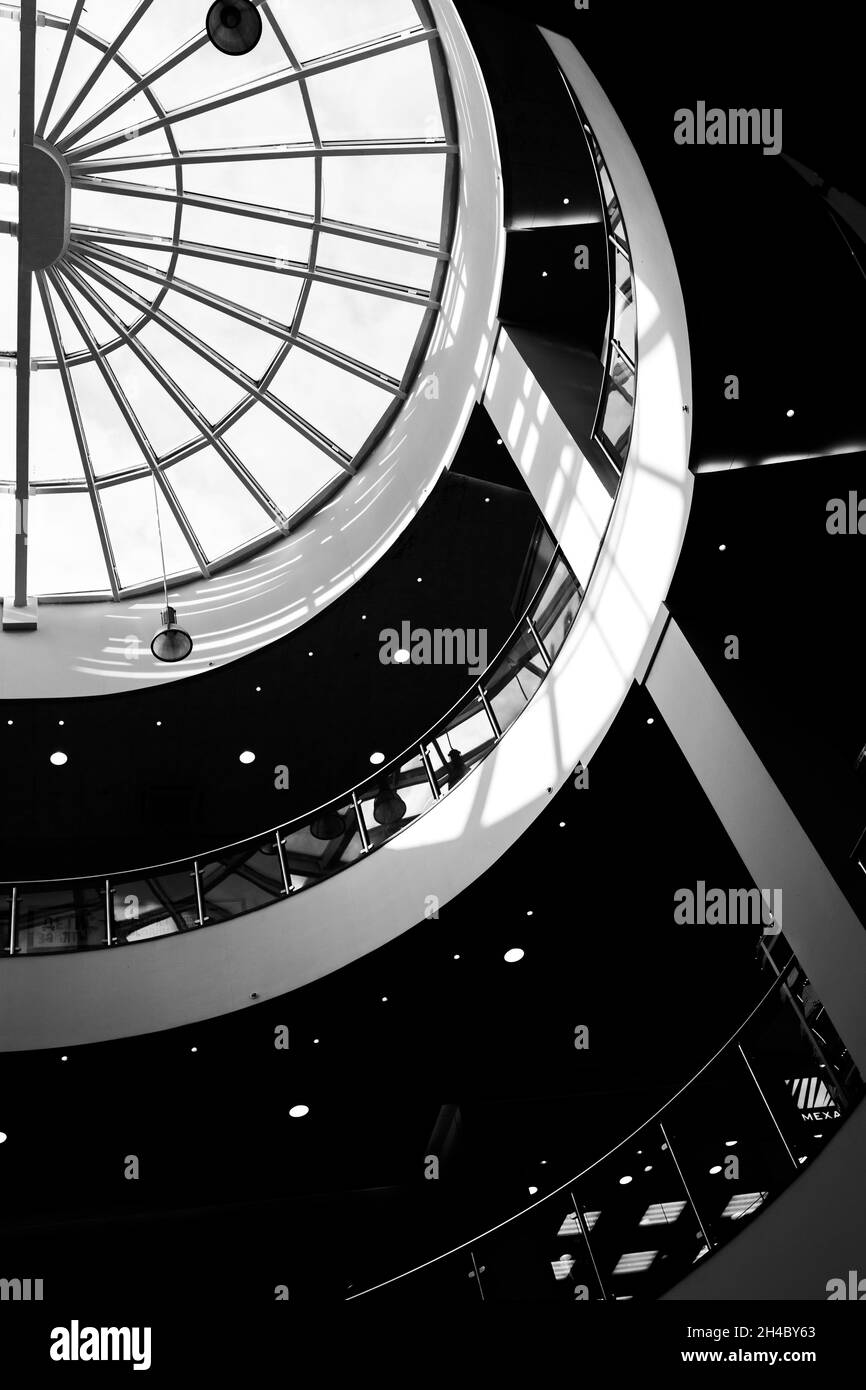 Atrium eines großen Einkaufszentrums. Schwarz-Weiß-Aufnahmen im Kontrast. Geometrie und Licht. Die Leere der Mall. Stockfoto