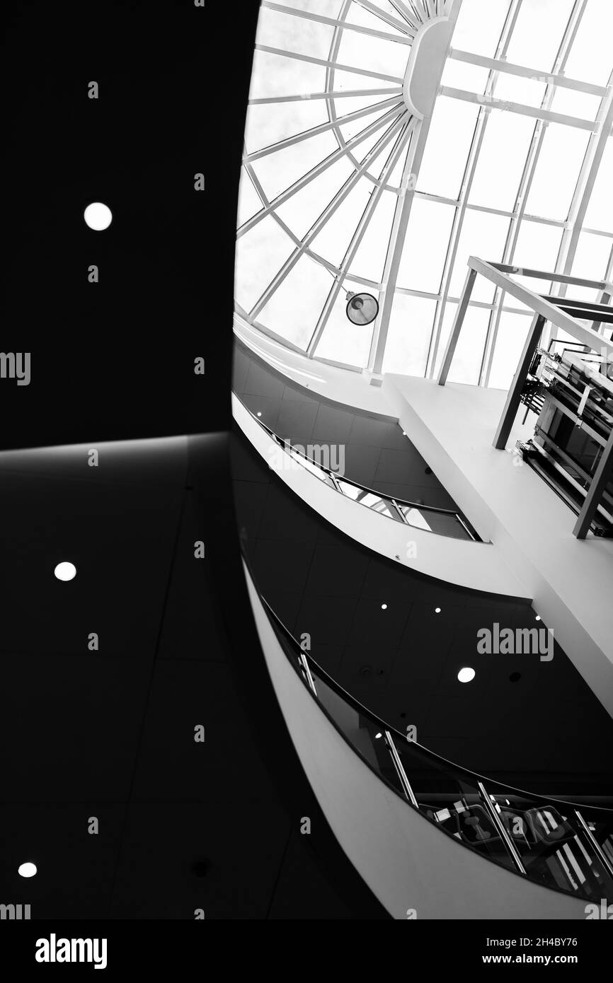 Atrium eines großen Einkaufszentrums. Schwarz-Weiß-Aufnahmen im Kontrast. Geometrie und Licht. Die Leere der Mall. Stockfoto