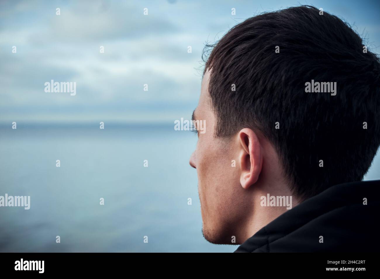 Der Typ schaut auf das Meer. Beschwichtigung. Stockfoto