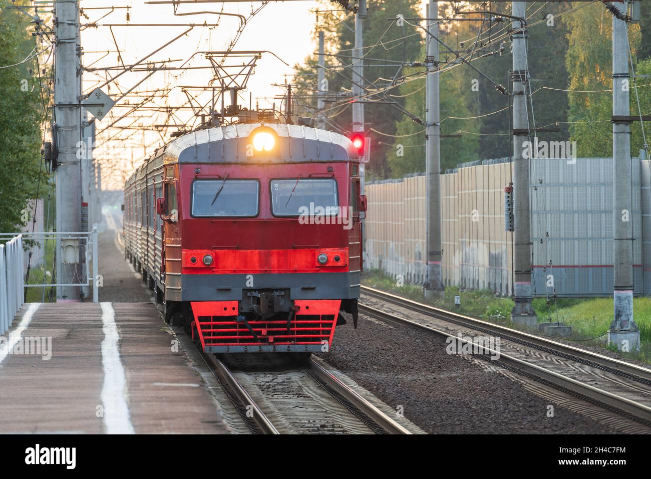 Der S-Bahn-Zug fährt bis zum Bahnhof. Pendlerzug für Passagiere, der auf die leere Plattform kommt Stockfoto