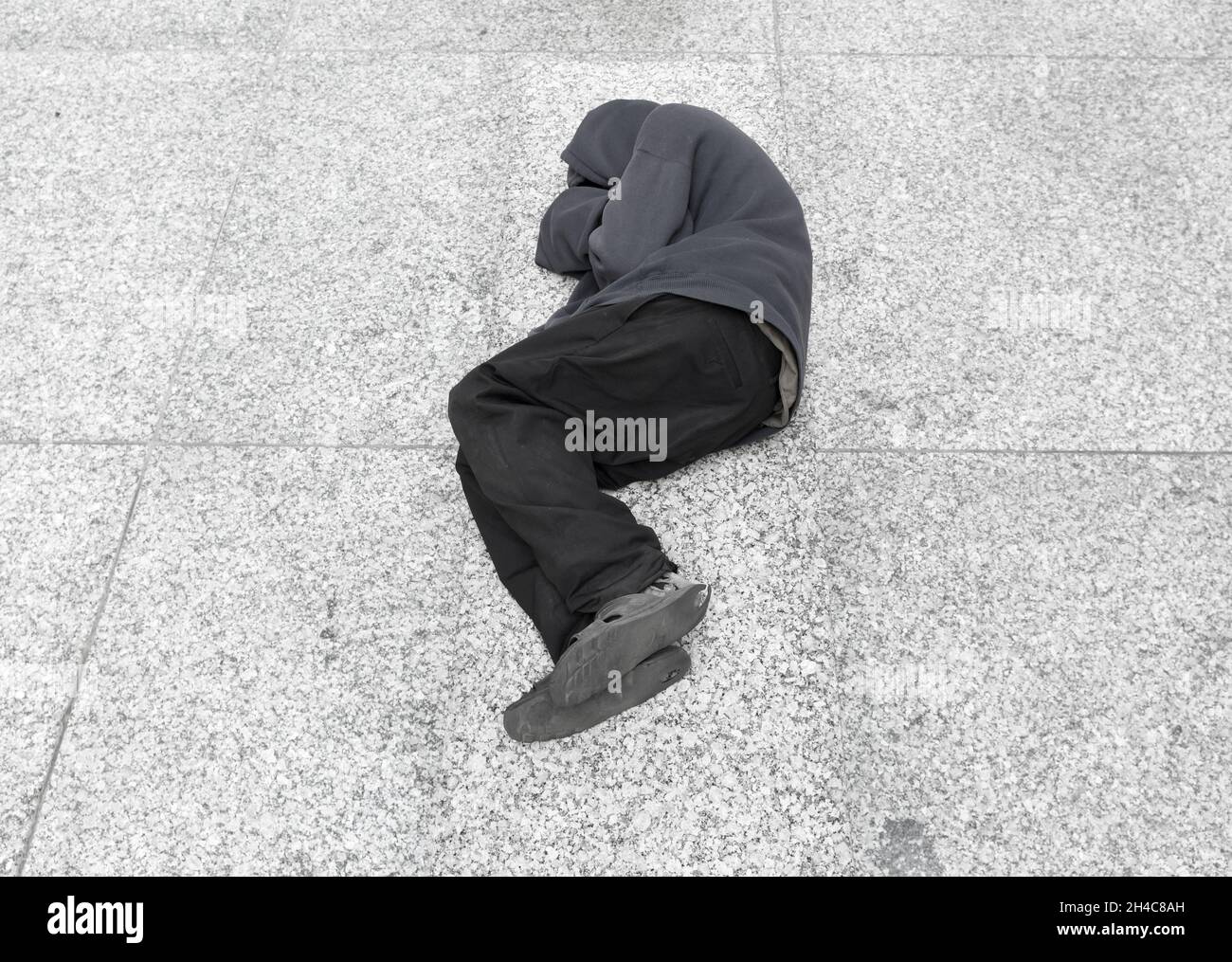 Obdachloser schläft auf dem Boden im Stadtzentrum Stockfoto