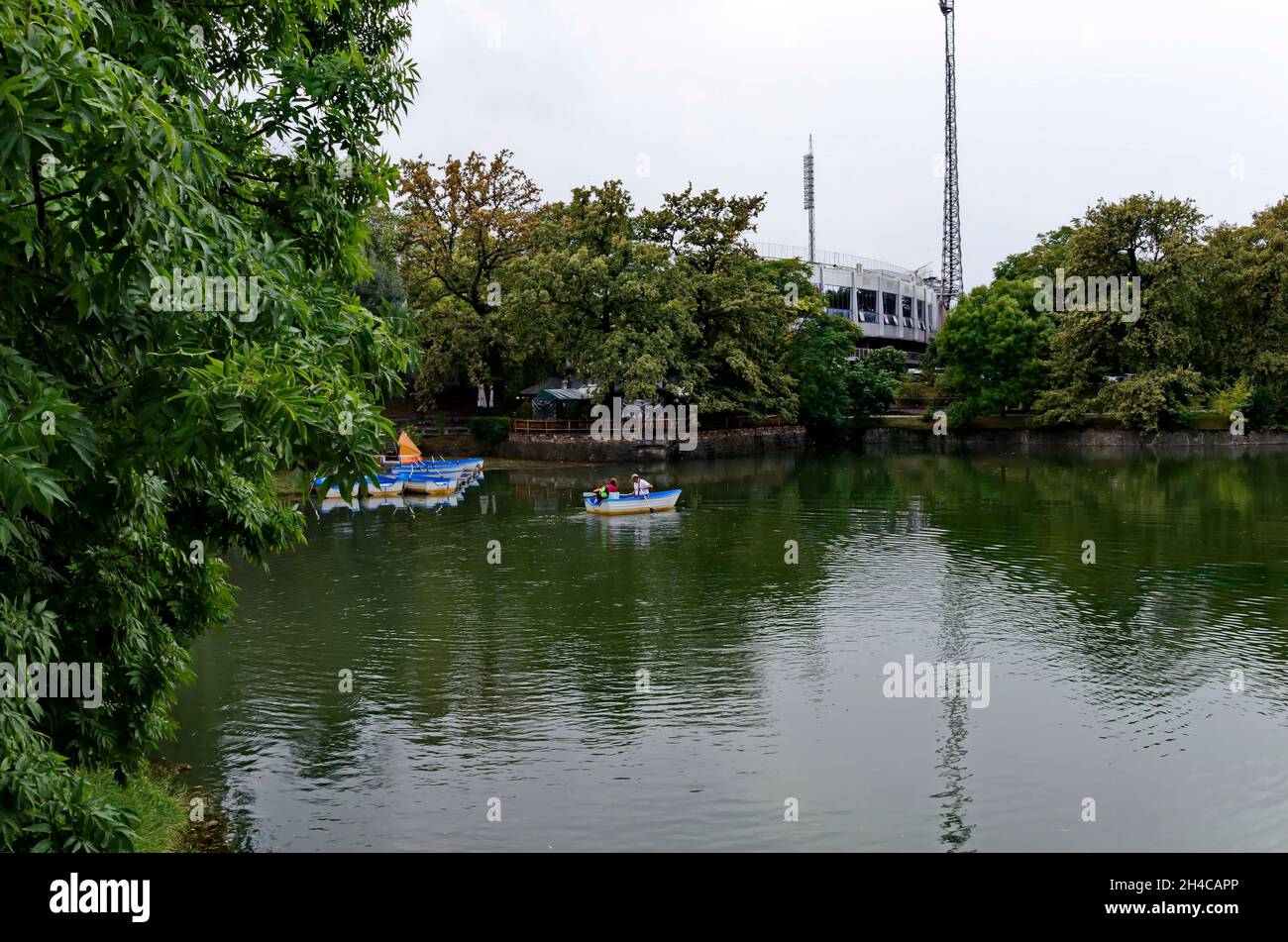 Gemütliche Ecke für Entspannung mit hölzernen Ponton und Boote nach dem Regen in See Ariana, Park Borisova gradina, Sofia, Bulgarien Stockfoto