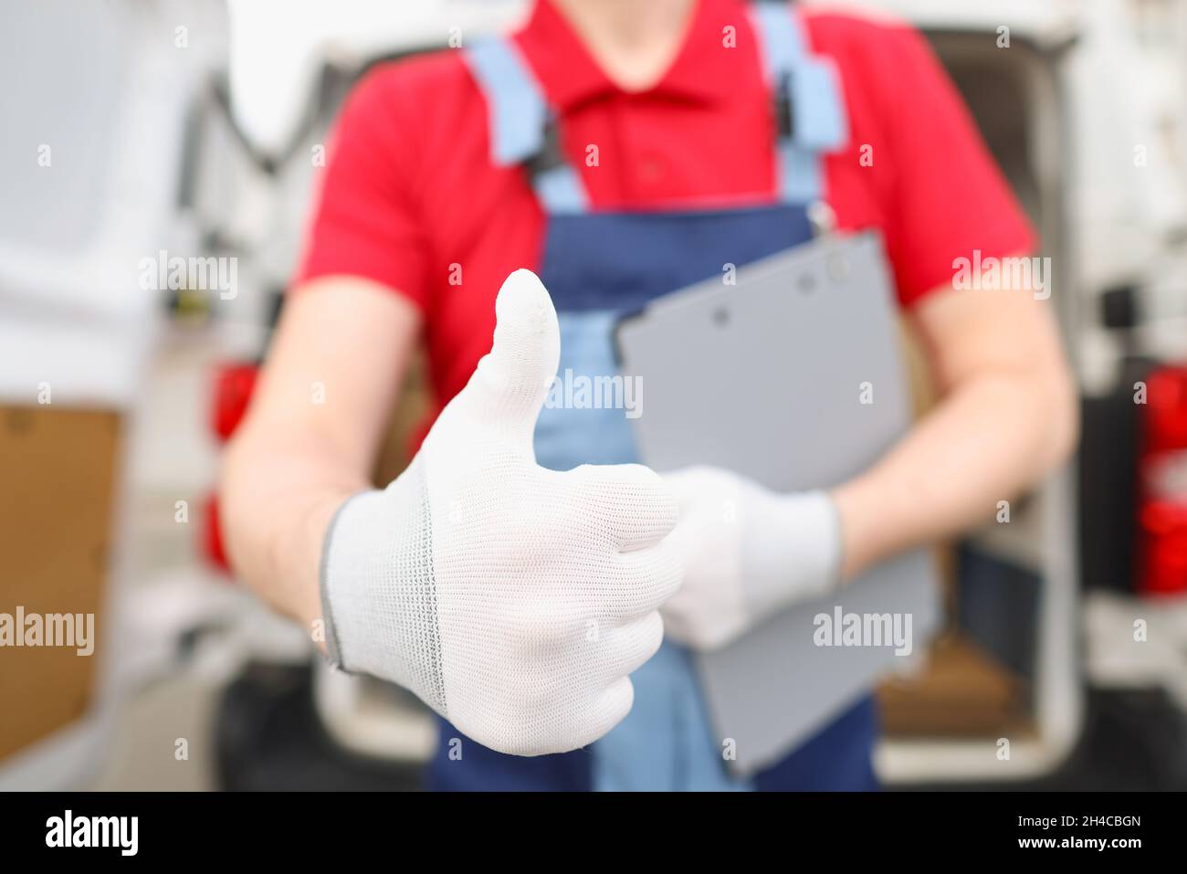 Männlicher Kurier zeigt Hand in Handschuh Geste ok Stockfoto