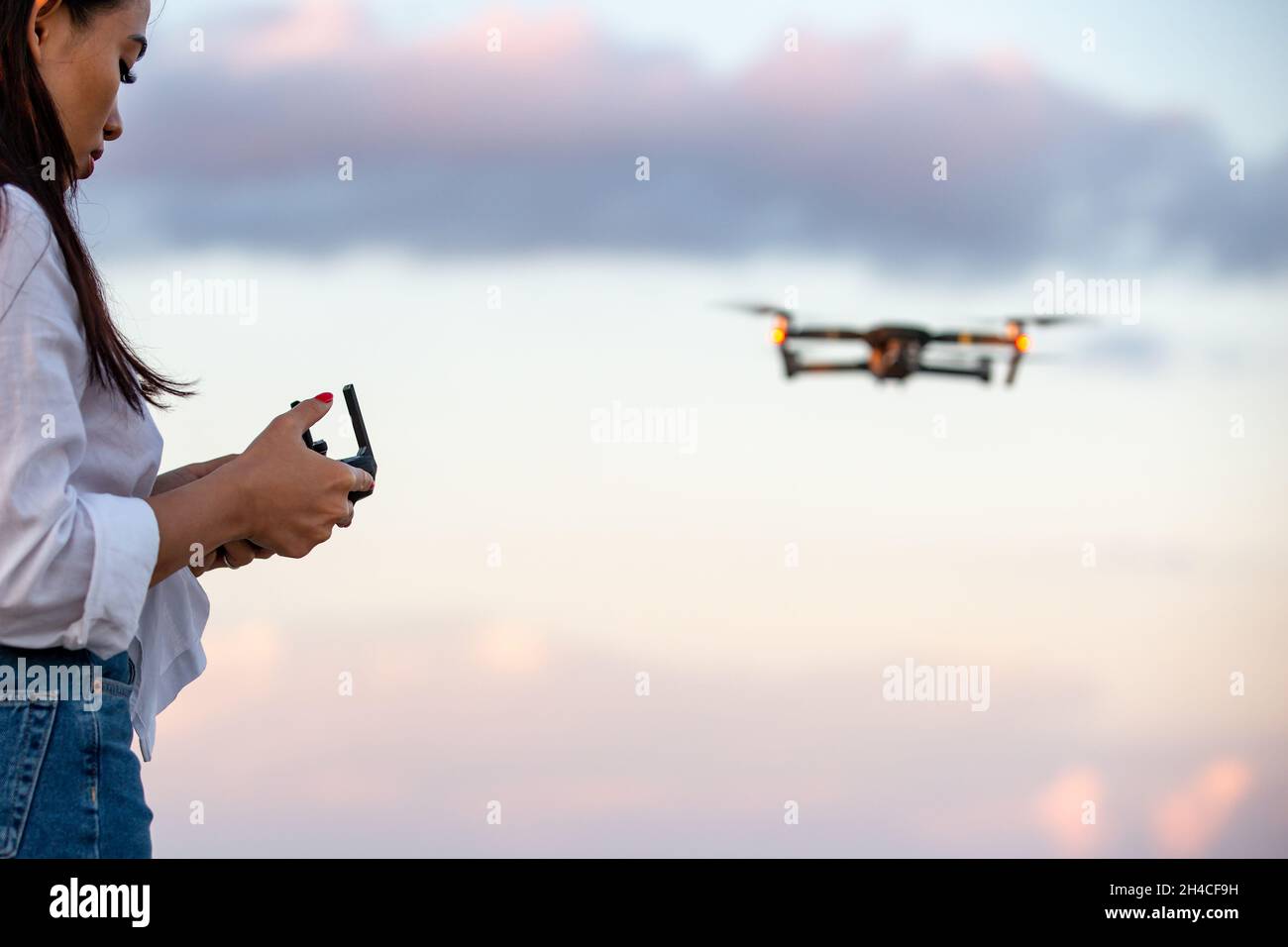 Eine junge Frau, die eine Drohne UAV betreibt Stockfoto