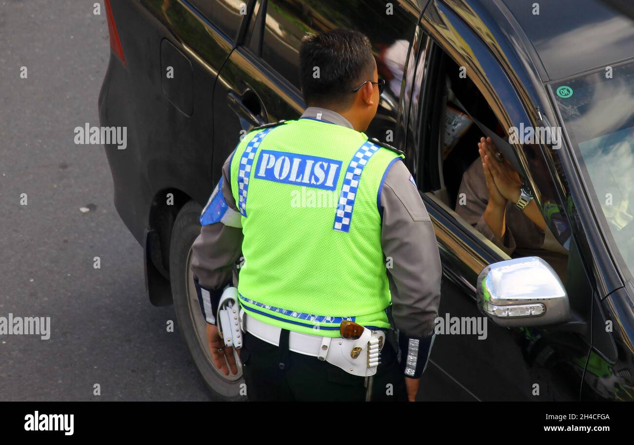 Ein Fahrer, der sich bei der Polizei für eine Verkehrsverletzung entschuldigt. Yogyakarta, Indonesien - Juli 2016. Stockfoto