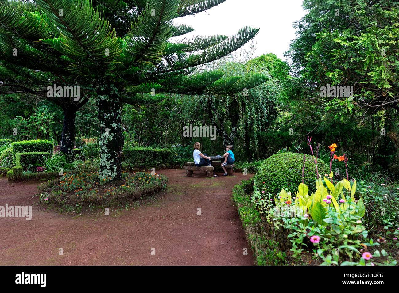 Mutter und Sohn sitzen im Garten eines Miradouro da Ponta do Sossego, Sao Miguel, Azoren, Portugal Stockfoto