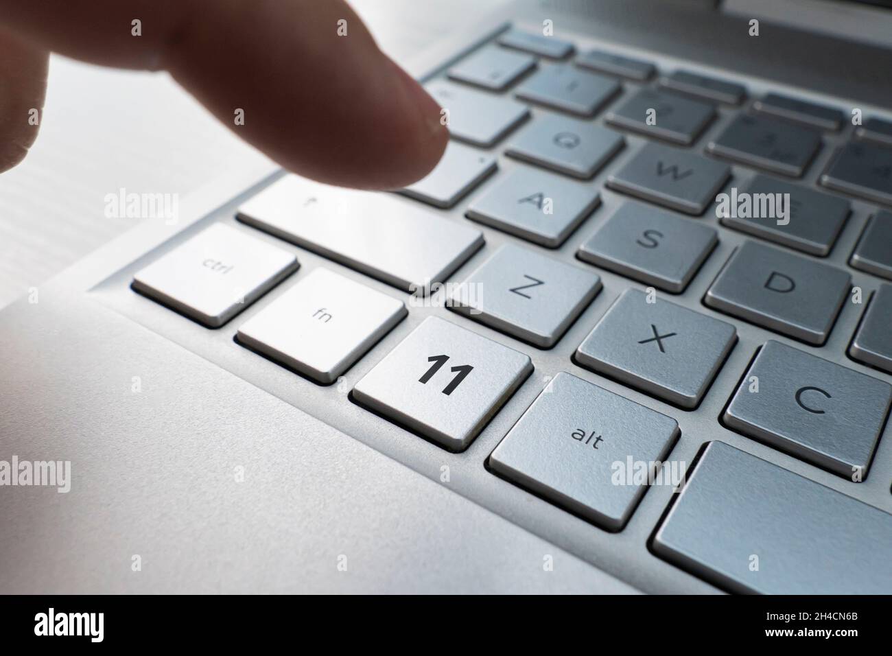Nahaufnahme des Fingers auf der Tastaturtaste mit dem Logo der Nummer 11 Stockfoto