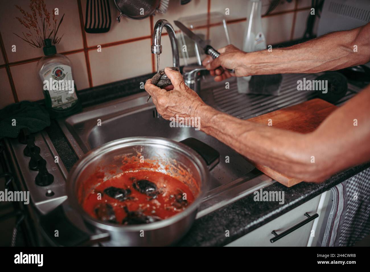 Hände von ethnisch unterschiedlichen leitenden Küchenaufgaben Stockfoto