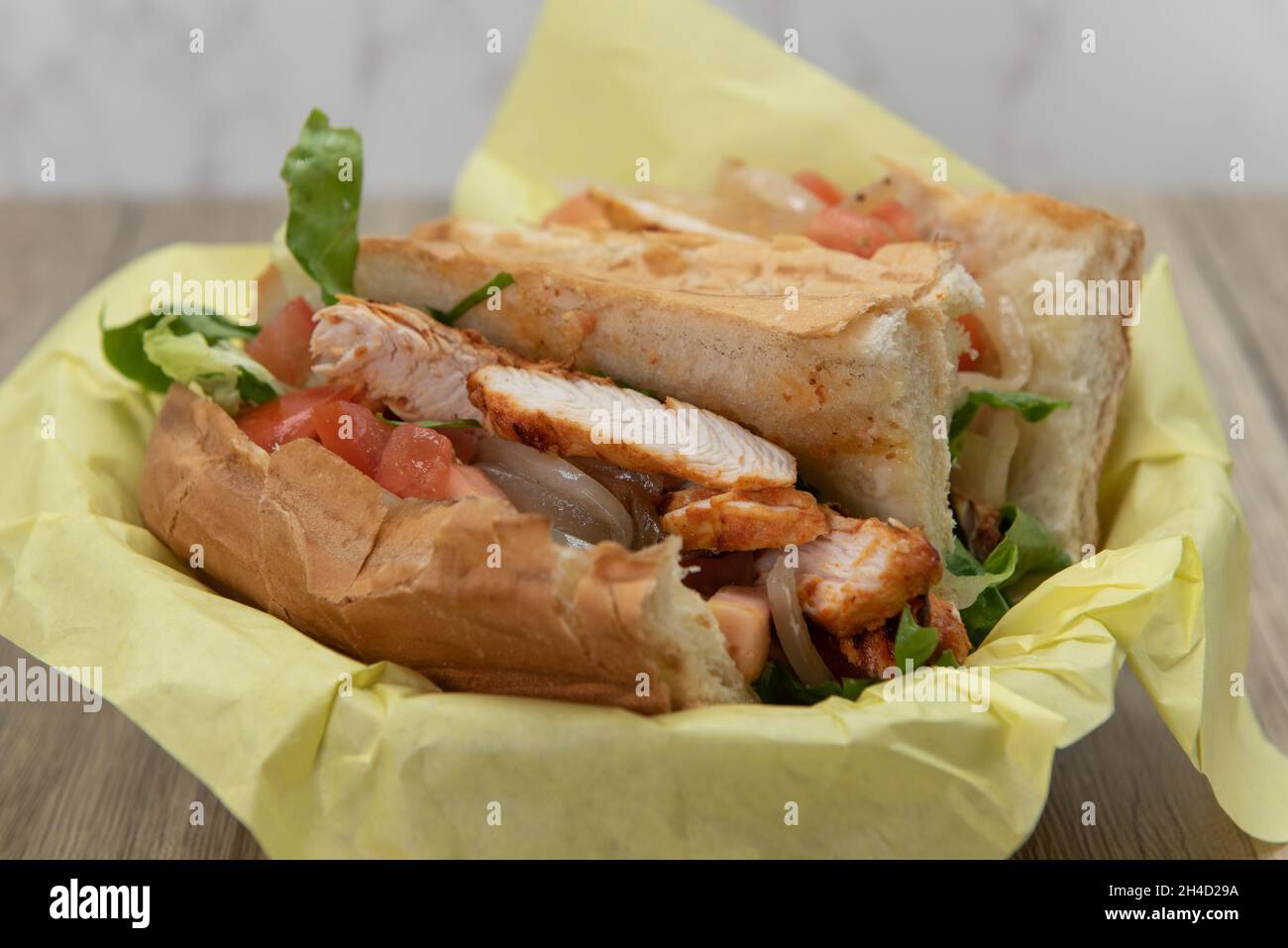 Beladen Tikka Hähnchen-Sub-Sandwich voller Füllungen in einem frisch gebackenen Brötchen. Stockfoto