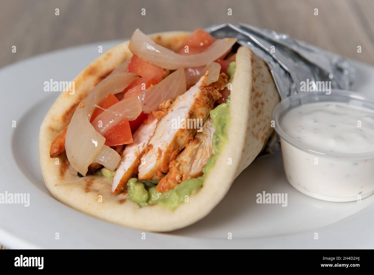 Beladen Tikka Chicken Fajita Wrap voller Füllungen in einem frisch gebackenen Pita Fladenbrot. Stockfoto