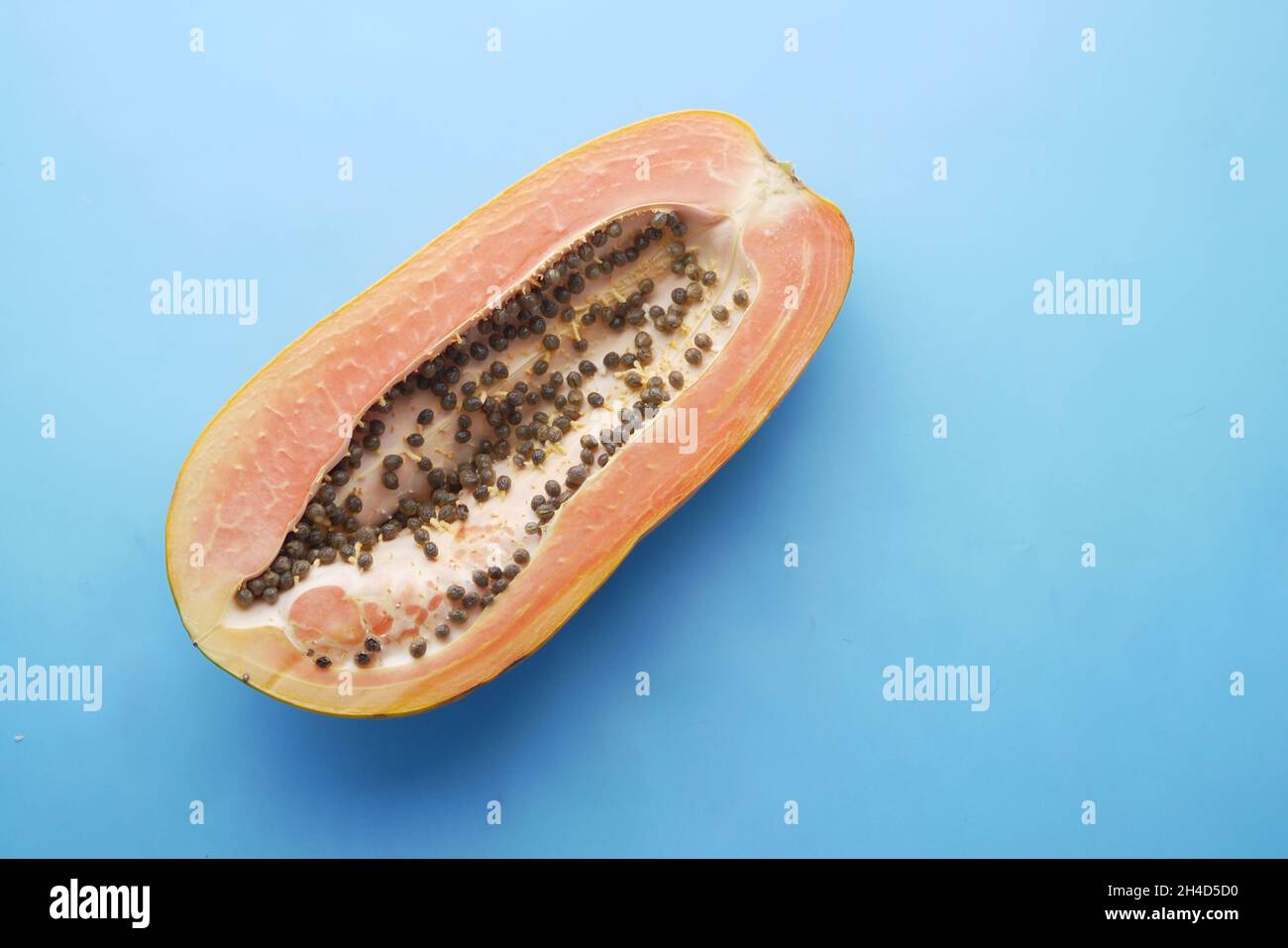 Papaya-Scheibe auf blauem Hintergrund mit Kopierraum Stockfoto